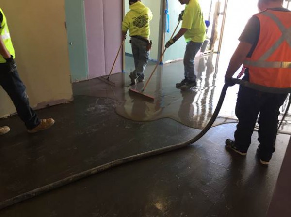 The crew from Fromkin Brothers Painting and Flooring installs PENETRON LEVELINE 15 underlayment over a shot-blasted substrate, a VB 225 moisture barrier and STX 100 Primer